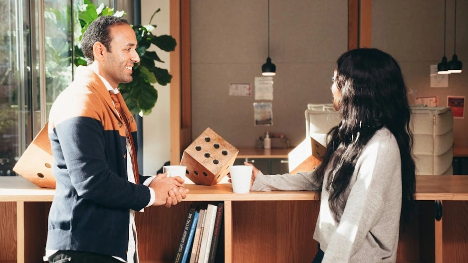 Due colleghi che discutono serenamente davanti a una lavagna.